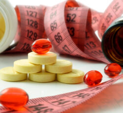 Measuring,tape,and,bottle,with,pills.,supplements,for,weight,loss